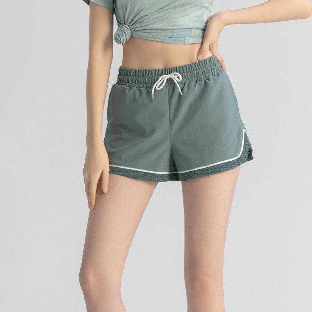 Women's workout shorts with adjustable drawstring, perfect for yoga. Features breathable, quick-dry fabric. Color: teal green.